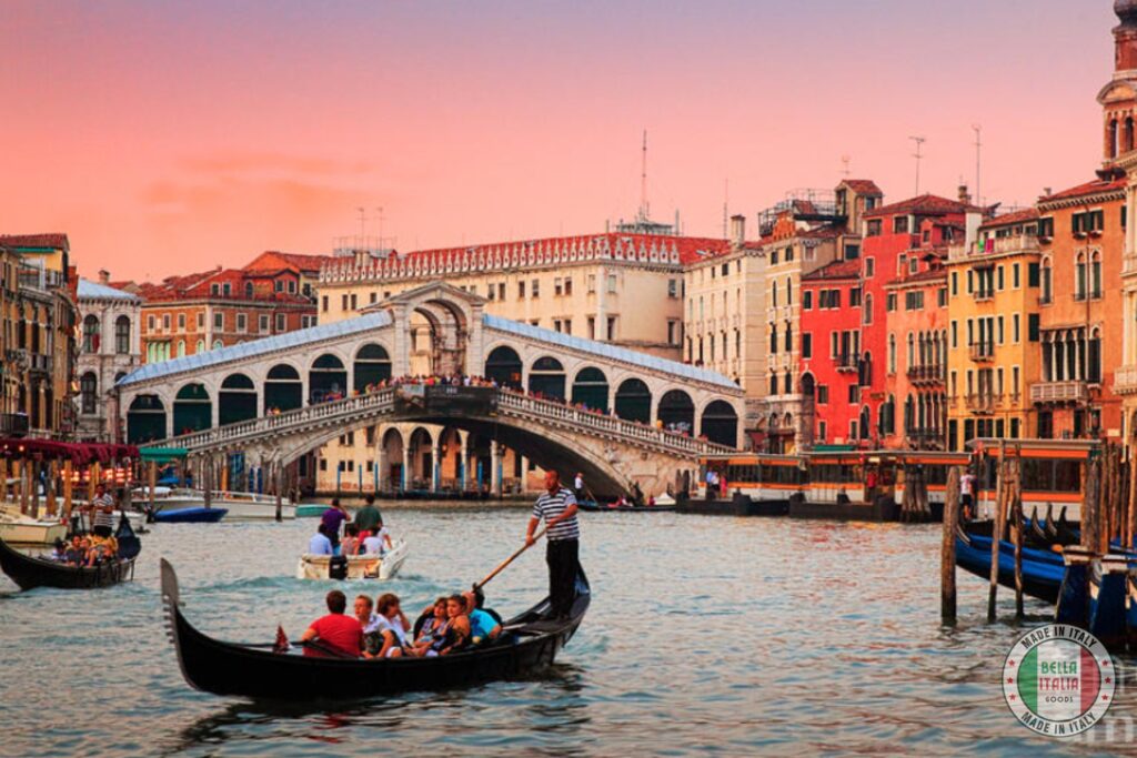 Gondola in front of Rialto bridge at dusk Venice Italy